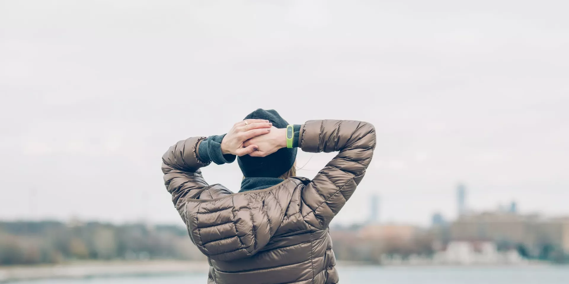wellness man holding behind head looking at water