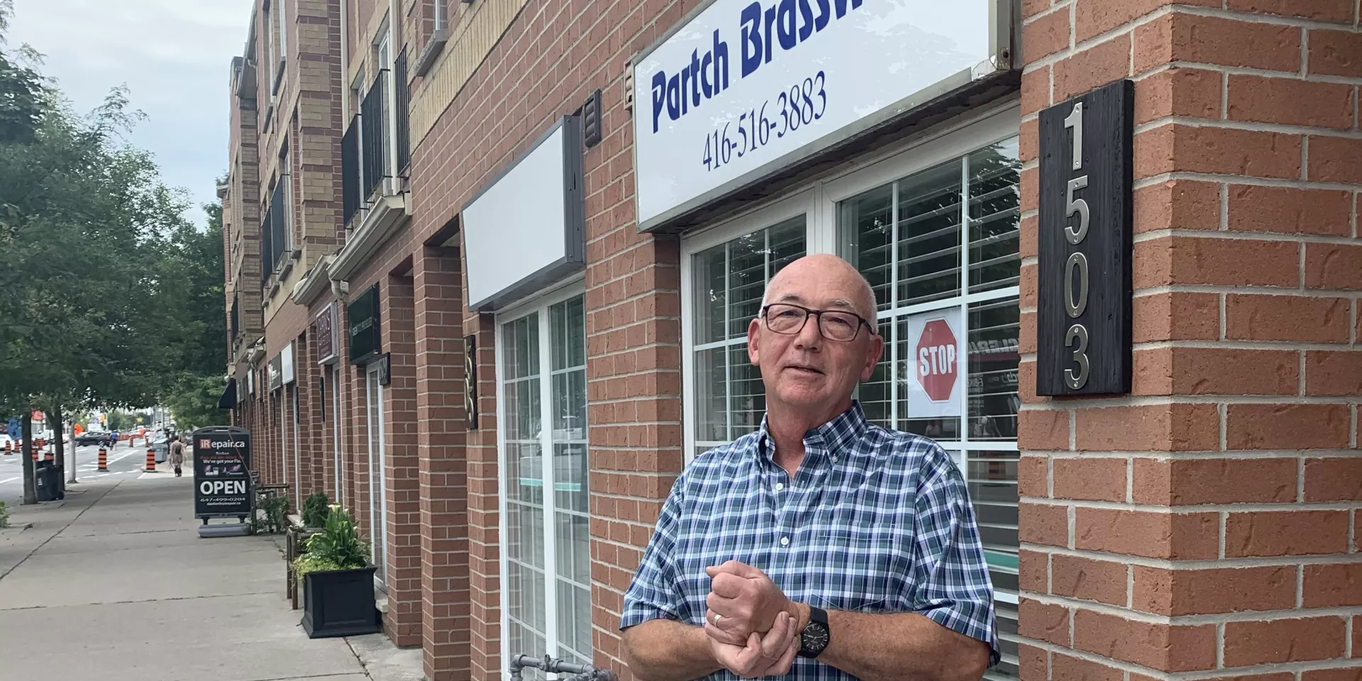Ron Partch outside his store, Partch Brasswinds  man standing on sidewalk in front of store