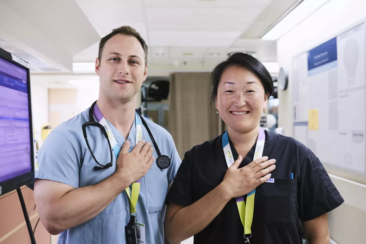 Love the East Two hospital staff members with their hands on their hearts
