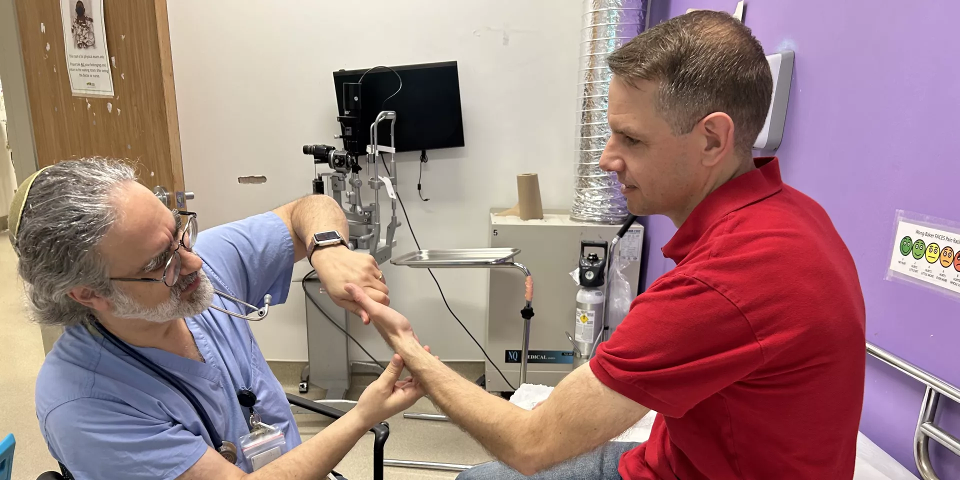Dr. David Rosenstein, information technology lead for our Stavro Emergency Department, assesses a patient’s injured wrist.