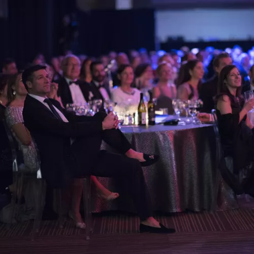 Gala audience people sitting at tables for gala event dark lit room