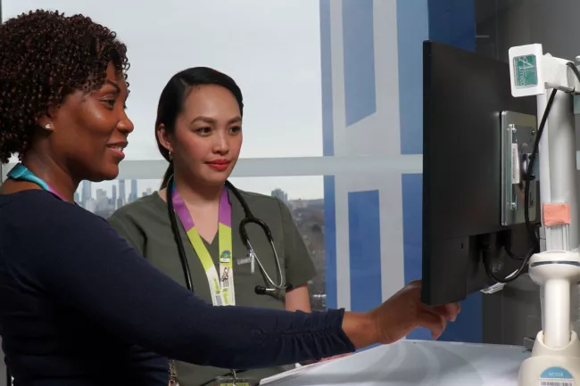 Supervisor Ann Marie Palmer and Registered Nurse Gwynn Fernandez collaborating on patient care.